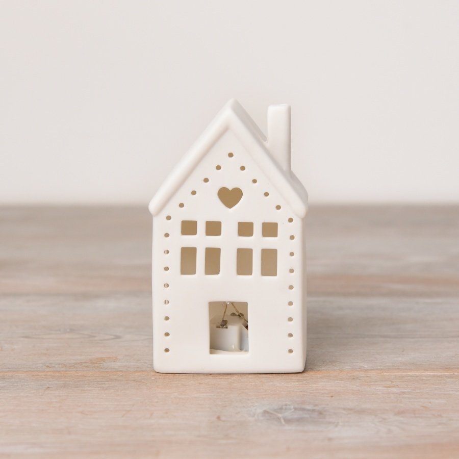 A light up ceramic house decoration with cut out design including heart motif. 