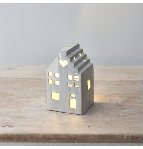 A stylish light up ceramic house with cut out details, heart motif and stepped roof design. 
