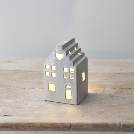 A stylish ceramic house with led tea light, stepped roof design and cut out details including a heart motif. 