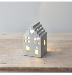 A stylish ceramic house with led tea light, stepped roof design and cut out details including a heart motif. 