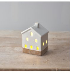 A classic ceramic house with warm glow LED lights and a white glossy glaze.