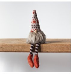 A fabric gonk designed to sit on a shelf, featuring fluffy beard and knitted striped legs with patterned hat. 
