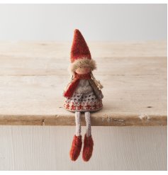 A charming knitted doll decoration dressed in Autumnal clothes in rich burnt orange hues.