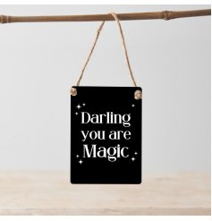 A mini metal sign with a monochrome design and "darling you are magic" text.