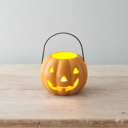 A classic pumpkin shaped lantern with an orange speckled finish and black carry handle.