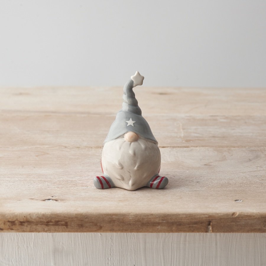 A gorgeous sitting ceramic Gonk ornament with red and grey legs and a cute star twisted hat. 