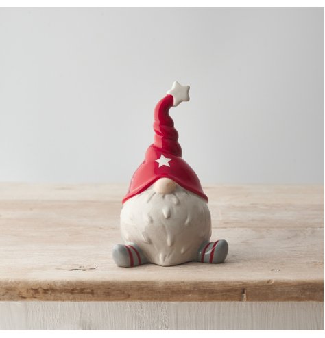 A unique and stylish sitting ceramic gonk decoration with a festive red hat and star detailing. 