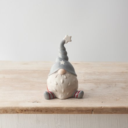 A chic ceramic gonk ornament with red and grey stripy legs and a cute twisted hat with star detail.
