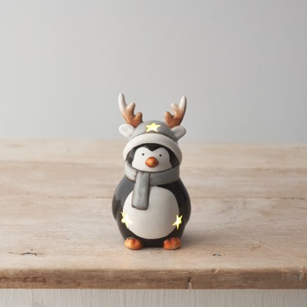 A cute ceramic penguin ornament with a glossy glaze and warm glow LED lights. 