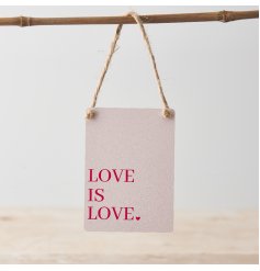 A cute mini metal sign in a pretty pink colour with red text featuring "love is love" message alongside a heart detail. 