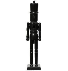 A contemporary wooden nutcracker painted with a black finish. A contemporary and stylish seasonal decoration.