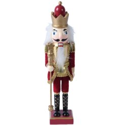 A beautifully detailed traditional nutcracker decoration in an ornate red and gold outfit. 