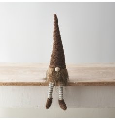 A cute gonk decoration with stylish sherpa fabric hat and shoe details with dangly striped legs in neutral brown tones.