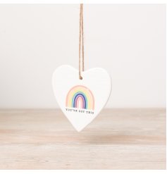 A heart shaped plaque with a rainbow motif and motivational slogan.