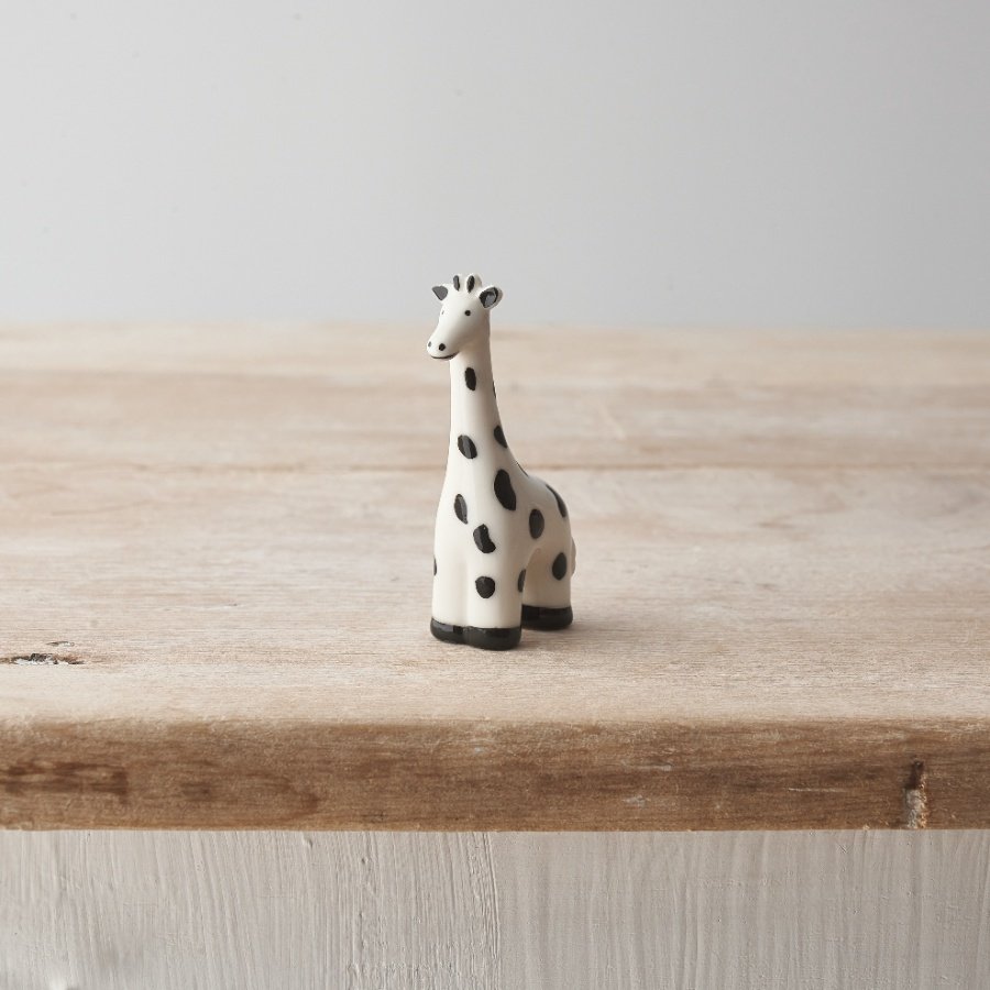 A small porcelain giraffe decoration with a monochrome colour scheme and spotted design. 