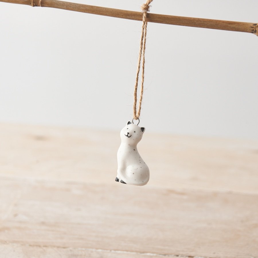 A mini porcelain cat hanging decoration with twine hanger, cute little face, speckled pattern design. 