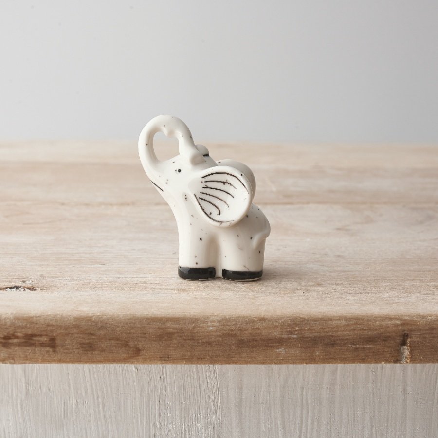 A small porcelain elephant decoration with a delicate speckled finish. 