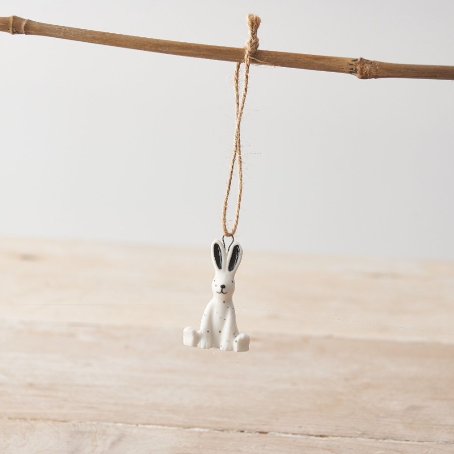 A small porcelain rabbit hanging decoration with monochrome design with speckled pattern and twine hanger.