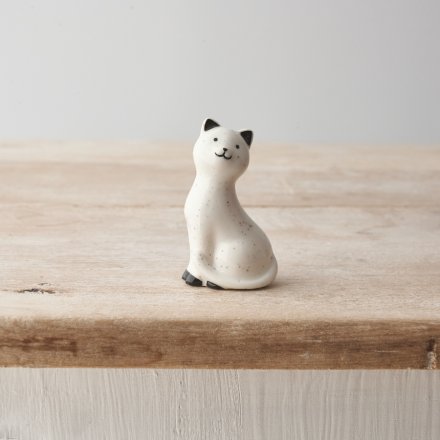 A mini porcelain cat ornament with cute little face and speckled pattern design. 