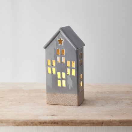 A ceramic house decoration with light up feature, cut out design and star detail. 
