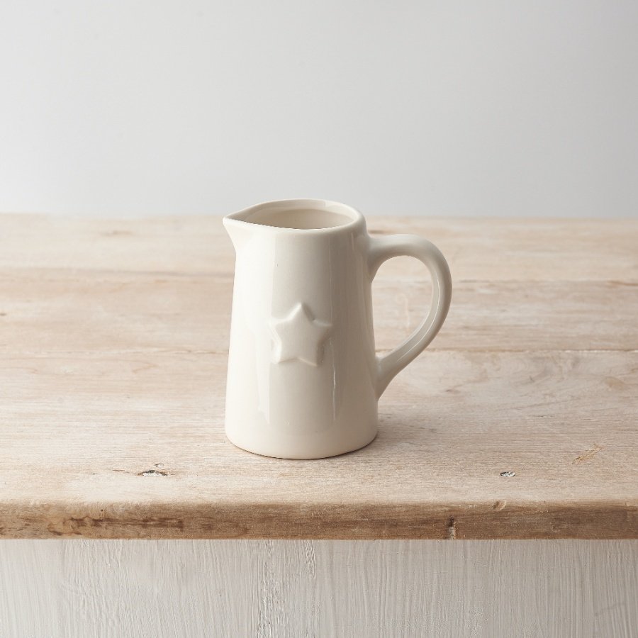 A stylish ceramic jug with a simple design and embossed star detail.