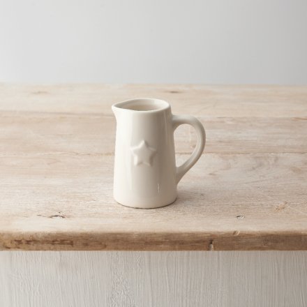 A small ceramic white jug with embossed star feature detail. 