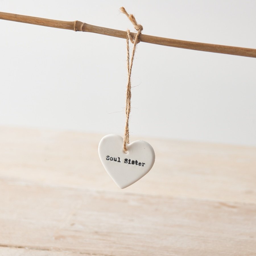 A ceramic heart hanging decoration with "soul sister" message and twine hanger. 