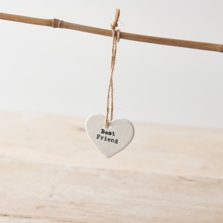 A simple yet stylish white ceramic heart hanging decoration with "best friend" message and twine hanger.