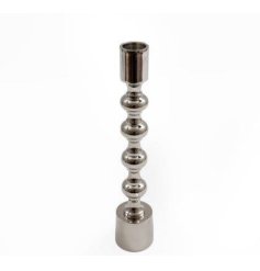A stylish medium sized candlestick with a silver coloured metal finish with an elegant shaped design. 