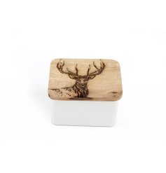 A metal tin with wooden lid featuring a etched stag design. 