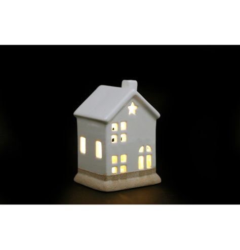 A charming light up house decoration with star cut out detail and contrasting base. 
