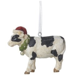 A traditional cow decoration wearing a Santa hat hung from silver string