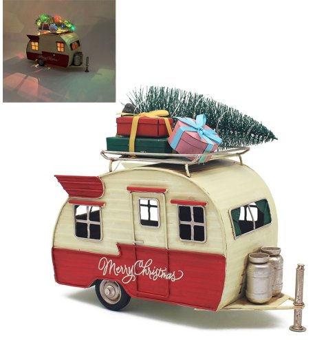 A retro style metal caravan with warm LED lights and a lit Christmas tree.