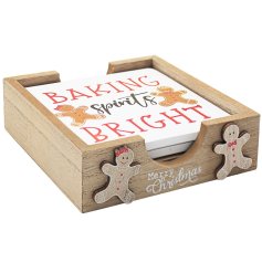 A set of 4 wooden coasters in a holder decorated with gingerbread men.
