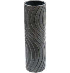A tall stoneware vase in a deep blue with a 3D wave pattern detail. 