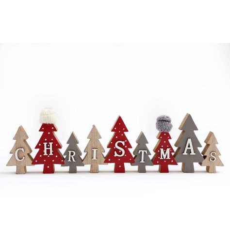 A wooden Christmas decoration of trees in traditional colours, with the word 'Christmas' embossed on the front.
