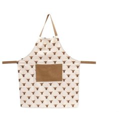 A cotton apron with a highland cow repeat pattern and contrasting pocket and ties. 