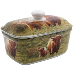 A butter dish featuring a highland cow and calf print within a beautiful countryside setting. 