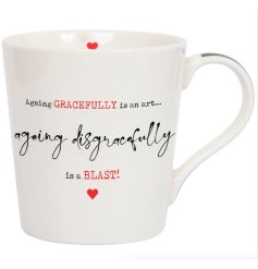 A classic white ceramic mug with humorous "ageing disgracefully is a blast" message and tiny red heart details. 