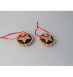 A festive decoration in the shape of a classic mince pie, hung from red ribbon