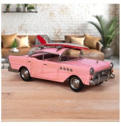 A metal car with surfboard decoration in a vivid pink colour with vintage styling!