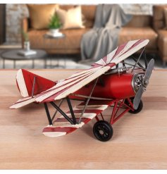 A vintage styled metal plane decoration with a colourful red finish and retro vibe. 