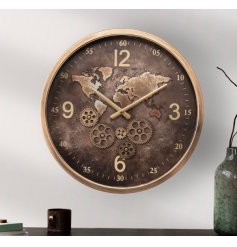 A large wall clock featuring gold details including edging and hands with cog detailing and world print. 