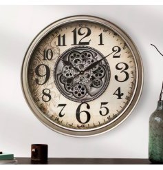 A large wall clock with central cog mechanism design, contrasting edge and delicately patterned print background.  
