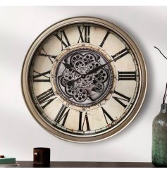 A large wall clock with central cog mechanism design, contrasting roman numerals and delicately patterned background. 