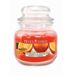 A colourful scented candle with a mandarin and ginger fragranced candle in a glass jar.