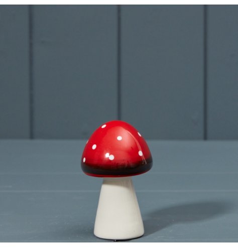 A nature inspired decoration in the shape of a mushroom, decorated in red with white polkadots.