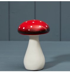 A charming ceramic decoration with white polkadots painted onto a red mushroom.