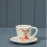 white cup and saucer set featuring a cheeky reindeer wearing a red scarf