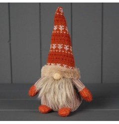 A rustic looking gonk in a festive patterned hat with a wooden nose.